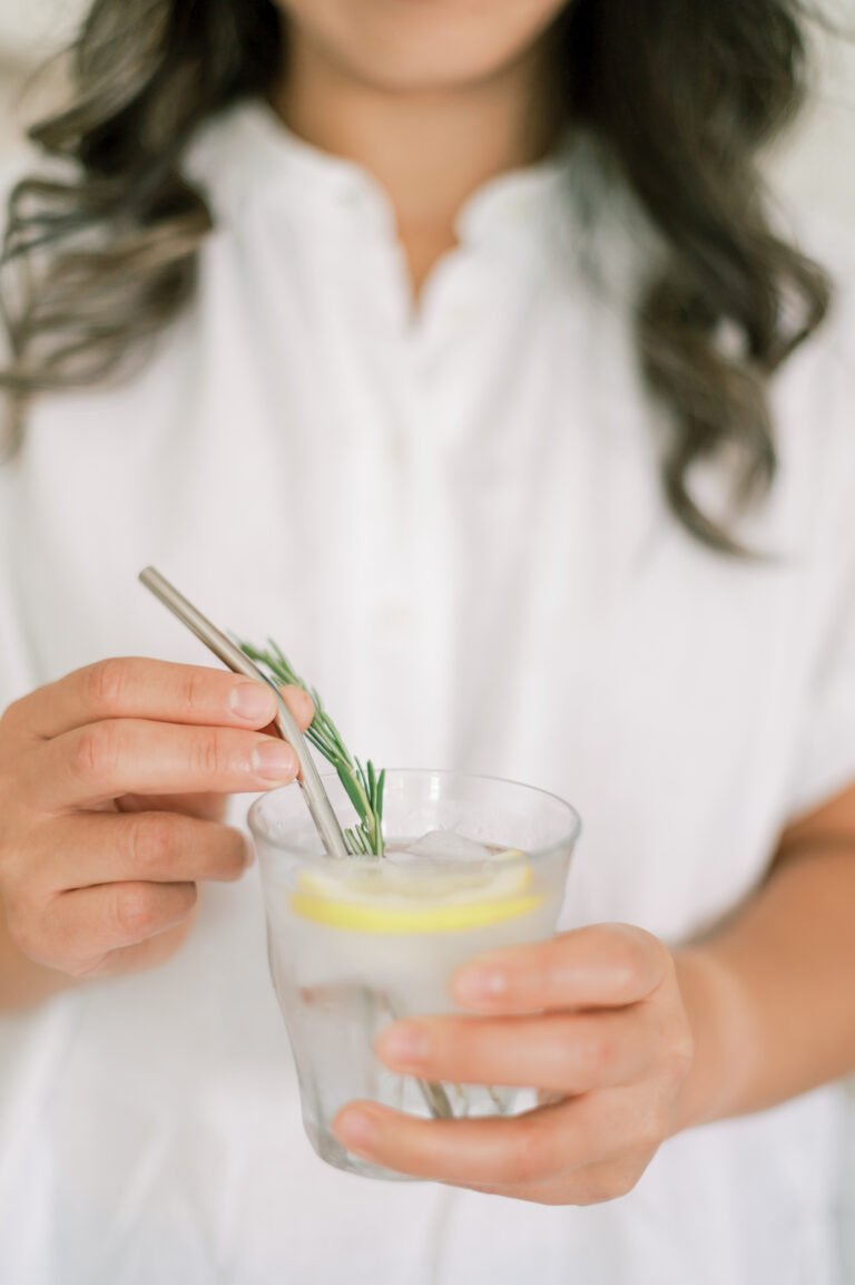 Woman drinking water with metal straw supporting metabolism and reducing inflammation in Garner Iowa